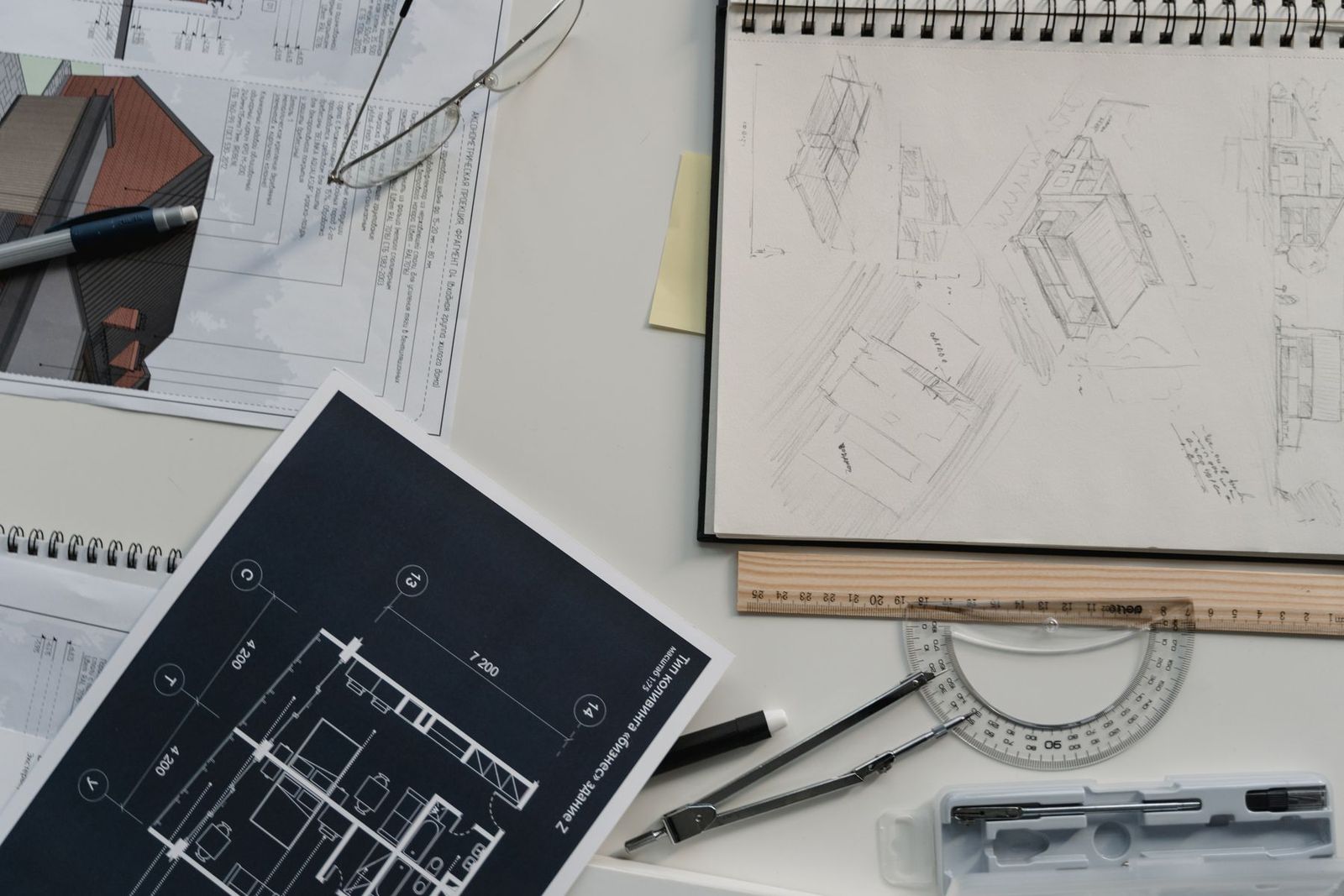 Architectural sketches, scale drawings and drafting tools on a desk